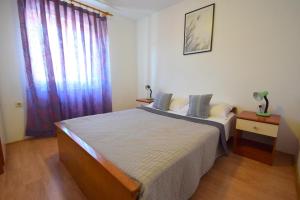 Un dormitorio con una cama grande y una ventana en Apartments Fejer, en Njivice