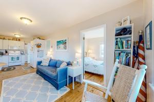 un salon avec un canapé bleu et une chambre dans l'établissement The Cottage, à Sandwich