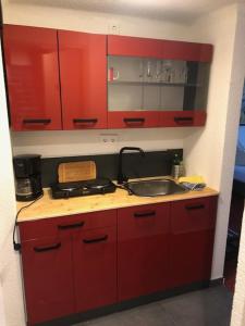 una cocina con armarios rojos y fregadero en Hotel Saarland Lebach, en Lebach