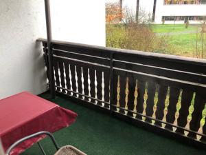 einen Balkon mit einem roten Tisch und einer Bank in der Unterkunft Hotel Saarland Lebach in Lebach