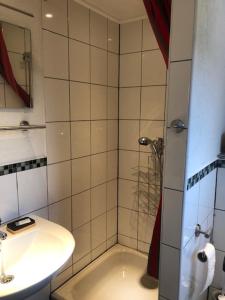 y baño con lavabo, aseo y ducha. en Hotel Saarland Lebach en Lebach