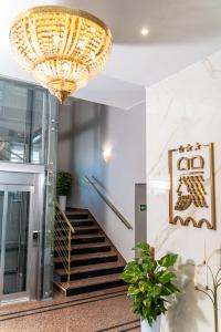 a large chandelier hangs over a staircase in a building at Hotel Piast in Opole