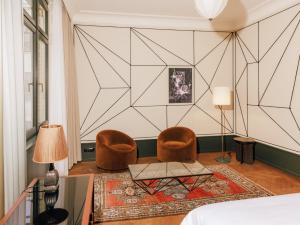 - une chambre avec deux chaises, une table et un lit dans l'établissement Boutique Hotel Château Royal, à Berlin