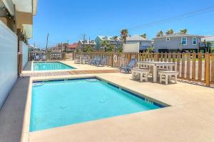 a swimming pool with a table and chairs and a picnic table and a picnic table at Stack Overflow in Port Aransas