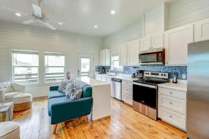 a kitchen with white cabinets and a blue couch at Stack Overflow in Port Aransas