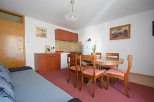 cocina y comedor con mesa y sillas en Apartments Fejer, en Njivice