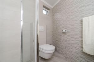 a white bathroom with a toilet and a shower at Sea view apartment 10 minutes walk from old city in Dubrovnik
