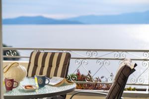 a table and chairs on a balcony with a view of the ocean at Villa Seaside View in Volos