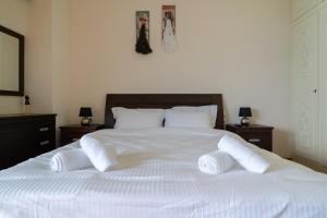 a white bed with two pillows on top of it at Villa Seaside View in Volos