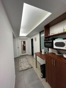 laila's boutique apartment في حيفا: غرفة معيشة مع مطبخ مع ميكروويف