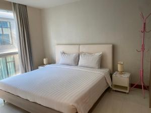 a bedroom with a large white bed with a window at Studio Bedroom with Kitchen in Bangkok
