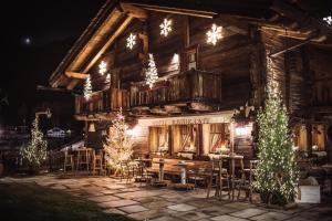 a log cabin with christmas lights in front of it at Hotel Chalet Svizzero in Courmayeur