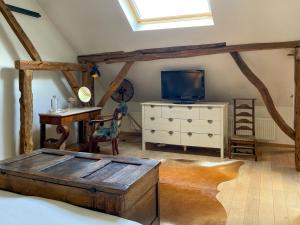 B&B De Paenhoeve في Eksel: غرفة نوم بسرير وتلفزيون وخزانة