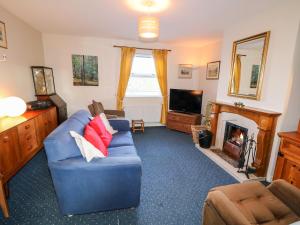 a living room with a blue couch and a fireplace at 17 Buninver Road in Omagh