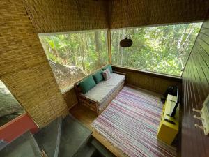 an inside view of a room with a couch in a window at Aruna espaco regenerativo in Florianópolis +129 photos