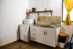 una pequeña cocina con fregadero y nevera. en Tacuifi I - Apartamentos en Los Reartes
