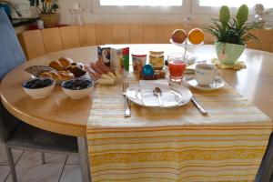 a wooden table with breakfast food on top of it at BNB Claudia in Appenzell