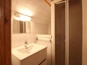 a white bathroom with a sink and a mirror at Chalet au Mont-Dore, 300m du centre, 6 pièces, garage, terrain pentu, idéal 8 pers, animaux non acceptés. - FR-1-608-4 in Le Mont-Dore