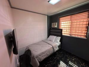 een kleine slaapkamer met een bed en een raam bij Clark pampanga( dale’s crib) in Mabalacat