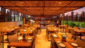 a restaurant with wooden tables and chairs and a restaurant at Infinity at the Sea by Matka in João Pessoa