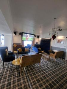 a living room with couches and a flat screen tv at The Grey Gull Hotel in Ardrishaig