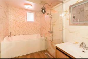 a bathroom with a shower and a tub and a sink at Appart hôtel le 8 Spa&Jacuzzi in Mâcon