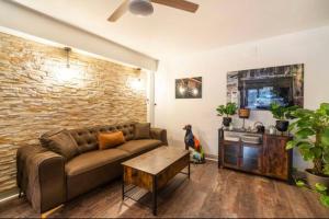 a living room with a couch and a brick wall at Appart hôtel le 8 Spa&Jacuzzi in Mâcon