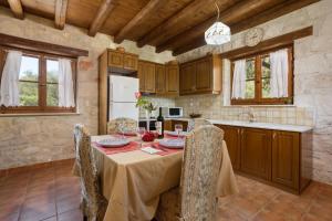 a kitchen with a table and chairs in a room at Artemis Stone Villa in Vasilikos