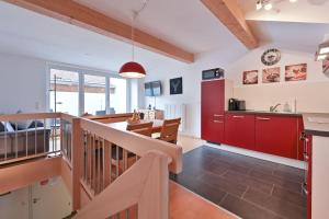 cocina y sala de estar con armarios rojos en Chalet am Breitenberg Appartement CB 09 en Pfronten
