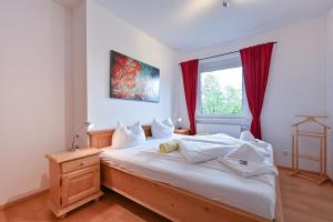 1 dormitorio con 1 cama y una ventana con cortinas rojas en Chalet am Breitenberg Appartement CB 09 en Pfronten