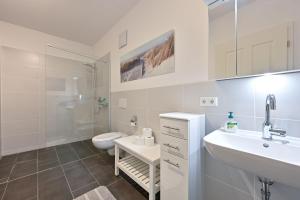 Baño blanco con aseo y lavamanos en Chalet am Breitenberg Appartement CB 09 en Pfronten