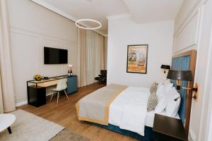 una camera d'albergo con un letto e una scrivania di Artist hotel a Subotica Altre 37 foto