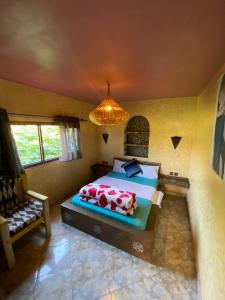 1 dormitorio con cama y lámpara de araña en Complexe rueda en Ouslaf
