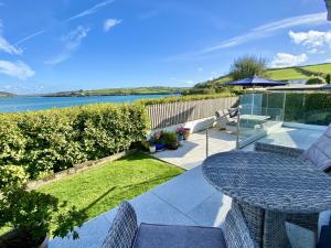 a patio with a table and a view of the water at Myebon in Padstow