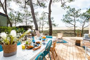 a picnic table on a deck with a view of the beach at Camping Le Bellevue in La Tranche-sur-Mer