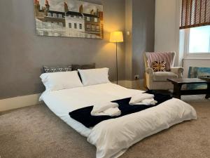 a large white bed in a room with a chair at Flat Near Richmond Upon Thames in Richmond