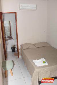 a bedroom with a bed and a chair and a mirror at POUSADA RODRIGUES in Barbalha