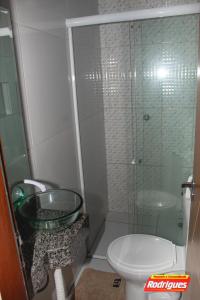 a bathroom with a toilet and a glass shower at POUSADA RODRIGUES in Barbalha