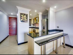 a large kitchen with a counter top in a room at The Sails Apartment in Durban