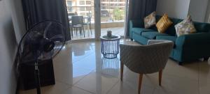 a living room with a blue couch and a fan at The Sails Apartment in Durban