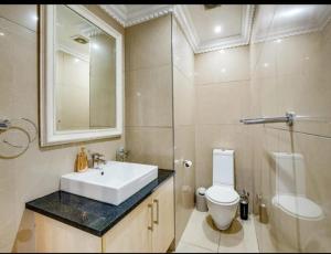 a bathroom with a sink and a toilet and a mirror at The Sails Apartment in Durban +9 photos