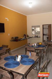 a dining room with wooden tables with blue napkins on them at POUSADA RODRIGUES in Barbalha