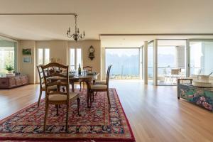 une salle à manger avec une table et des chaises sur un tapis dans l'établissement Lakeside Apartment - Grand appartement familial avec terrasses et vue panoramique, à Vevey
