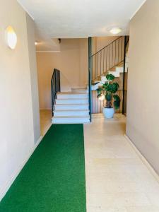 アオスタにあるApartamento da Jennyの廊下に緑の絨毯を敷いた階段