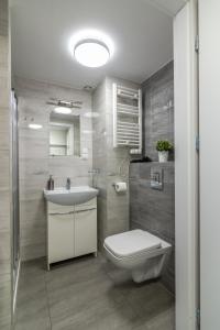 y baño con aseo blanco y lavamanos. en Studia przy lotnisku od WroclawApartament-pl, en Wroclaw