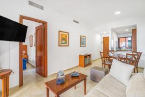 a living room with a couch and a table at Don Juan Beach Resort in Estepona +14 photos