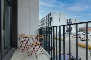 een balkon met 2 stoelen en een tafel op een gebouw bij Studia przy lotnisku od WroclawApartament-pl in Wrocław