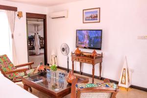 sala de estar con mesa y TV en Kahama Hotel Mombasa, en Bamburi
