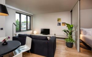 ein Wohnzimmer mit einem Sofa und einem Bett in der Unterkunft SANA Berlin Residence in Berlin