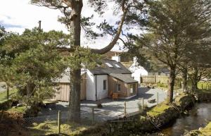 een klein wit huisje midden tussen de bomen bij Bridge Cottage in Luib